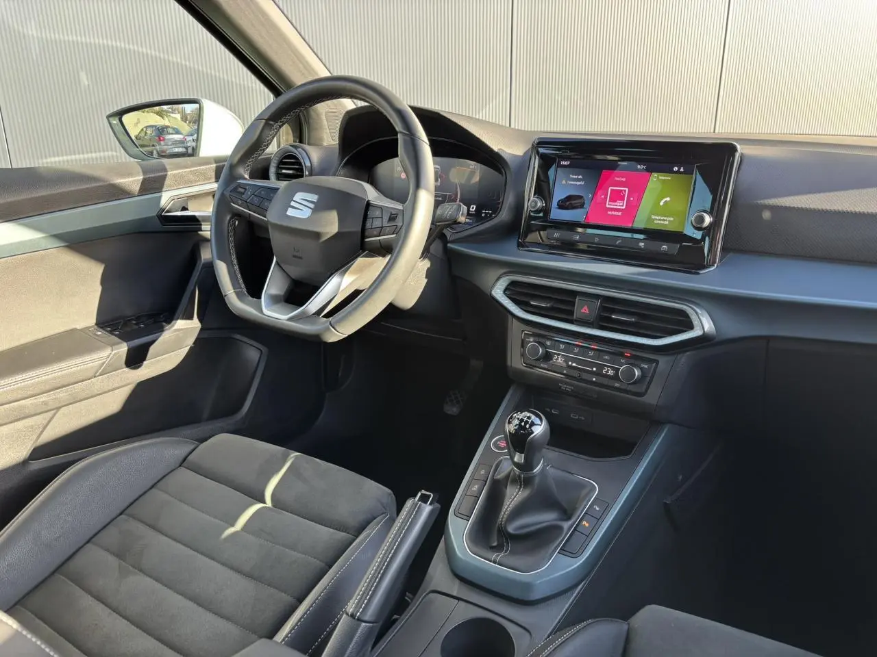 Intérieur avant droit du SEAT Arona TSI 115 Xpérience 2025, volant cuir, écran tactile et sellerie noire.