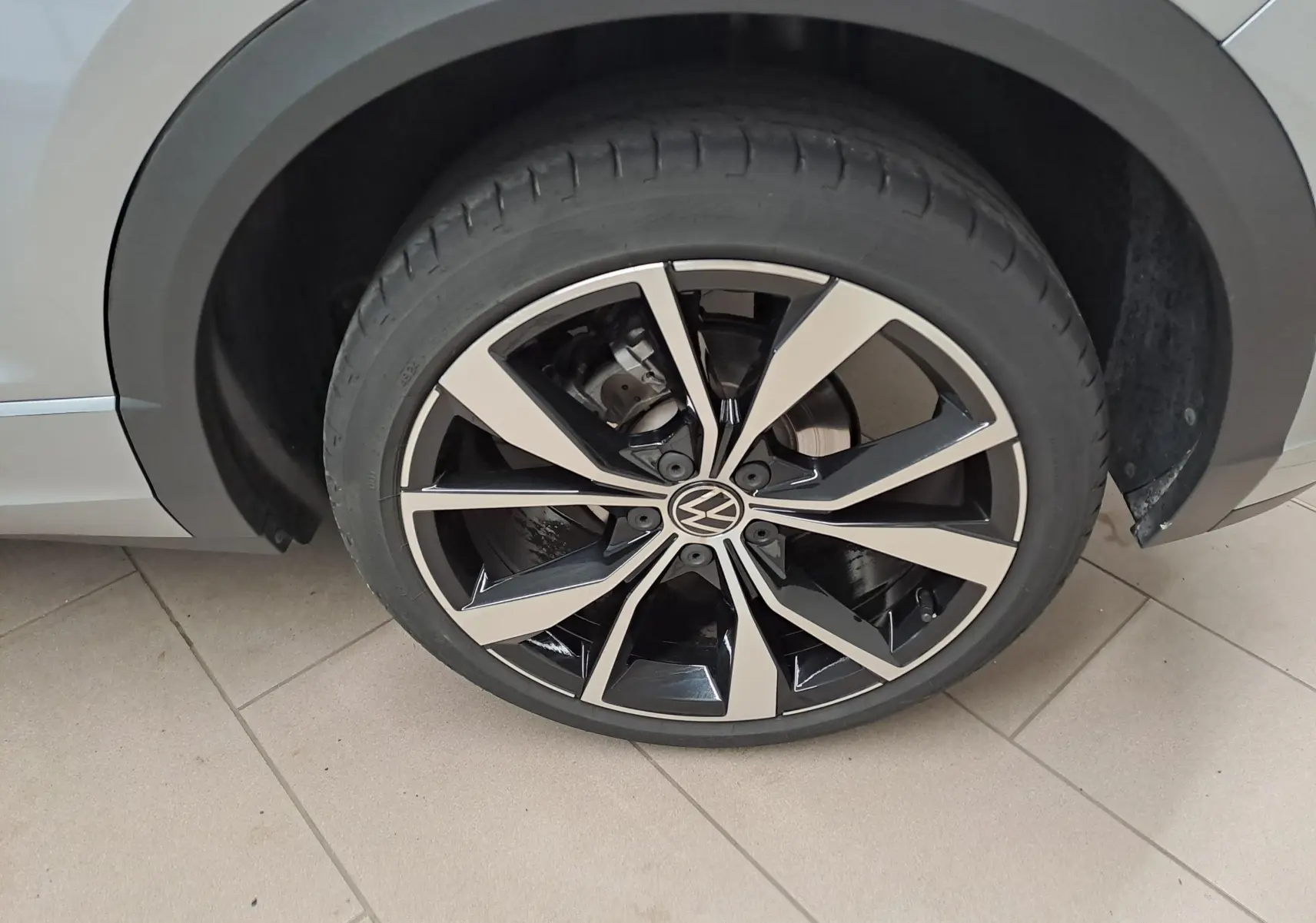 Gros plan sur la jante avant droite 19'' Misano noire et argent du Volkswagen T-Roc Gris Pyrite 2025.