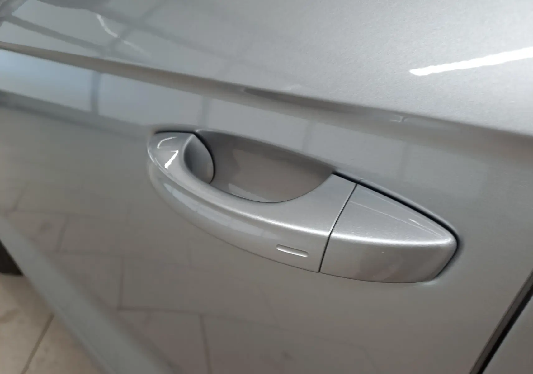 Poignée de porte côté gauche en gros plan sur Volkswagen T-Roc gris pyrite métallisé.