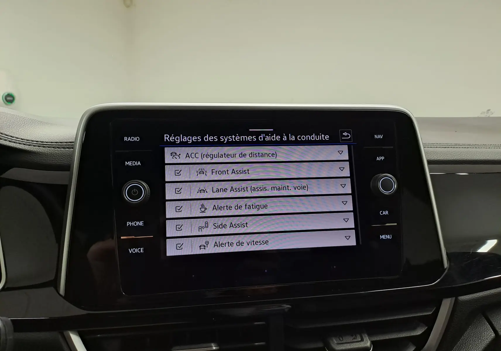 Écran tactile central du Volkswagen T-Roc 2025 affichant les réglages des aides à la conduite dans l'habitacle.