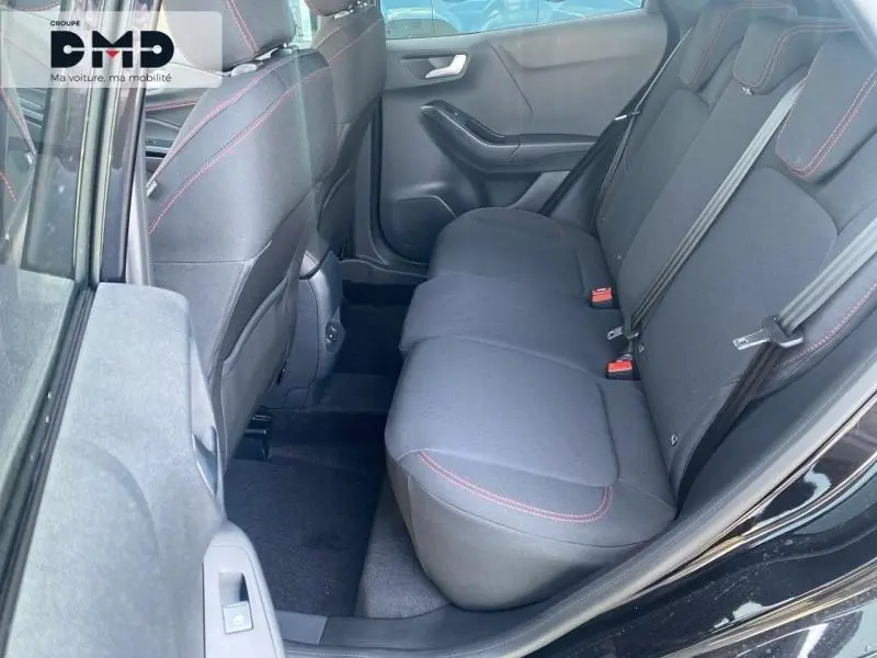 Vue côté droit de l’habitacle arrière du Ford Puma noir Agate, avec sièges tissu noir et surpiqûres rouges.