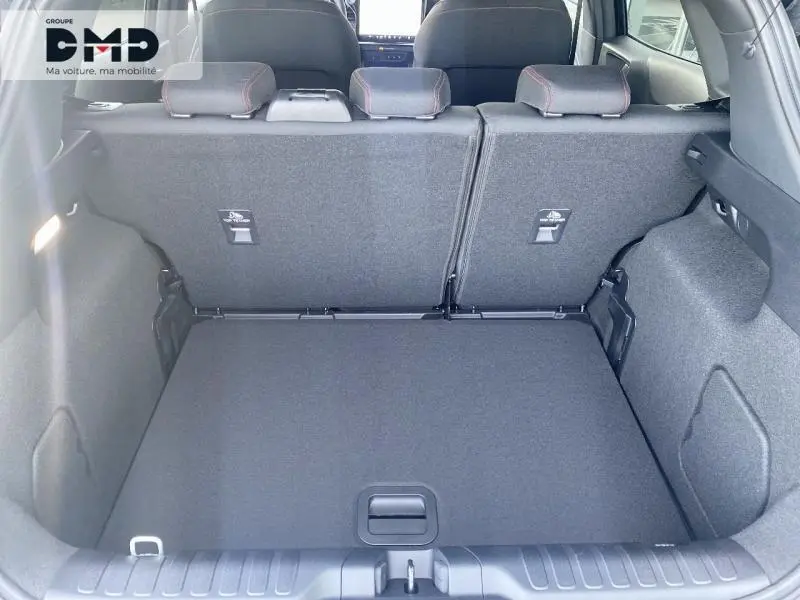 Vue intérieure du coffre spacieux du Ford Puma noir Agate Métallisée, avec banquette arrière rabattue et habillage gris.