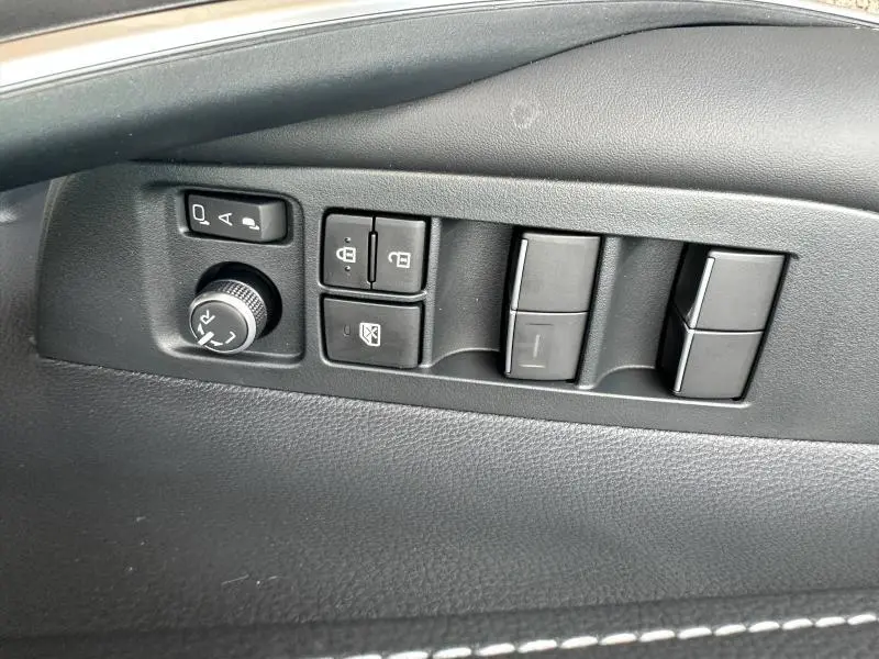 Panneau de commandes noir côté gauche sur porte intérieure de Toyota Corolla 2025, avec réglage rétroviseurs et vitres électriques.