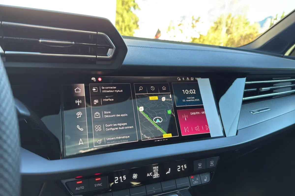 Tableau de bord de l'Audi A3 TFSI 150 Hybrid S-Line 2025 en noir mythic, vue de face sur l'écran tactile central et commandes climatisation.