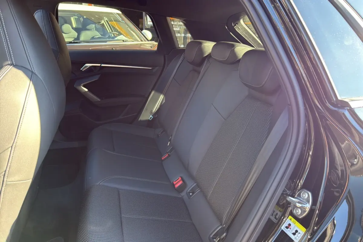 Vue côté droit des sièges arrière en cuir tissu noirs de l'Audi A3 TFSI 150 Hybrid S-Line 2025 avec portière ouverte.