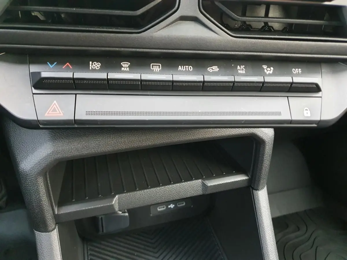 Vue rapprochée de la console centrale du Dacia Duster blanc Glacier 2025, montrant les commandes climatisation et deux prises USB type C.