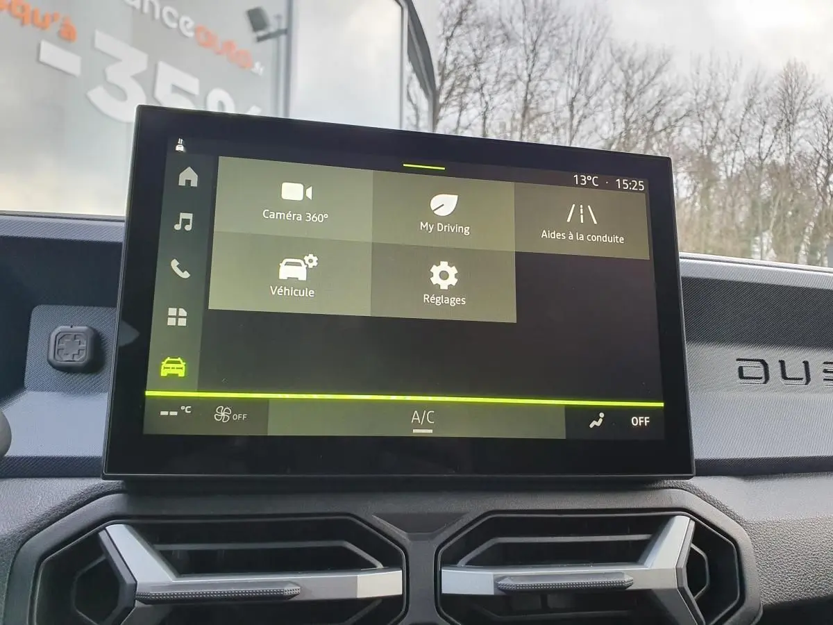 Écran tactile central du tableau de bord du Dacia Duster 2025 avec interface des aides à la conduite visible.