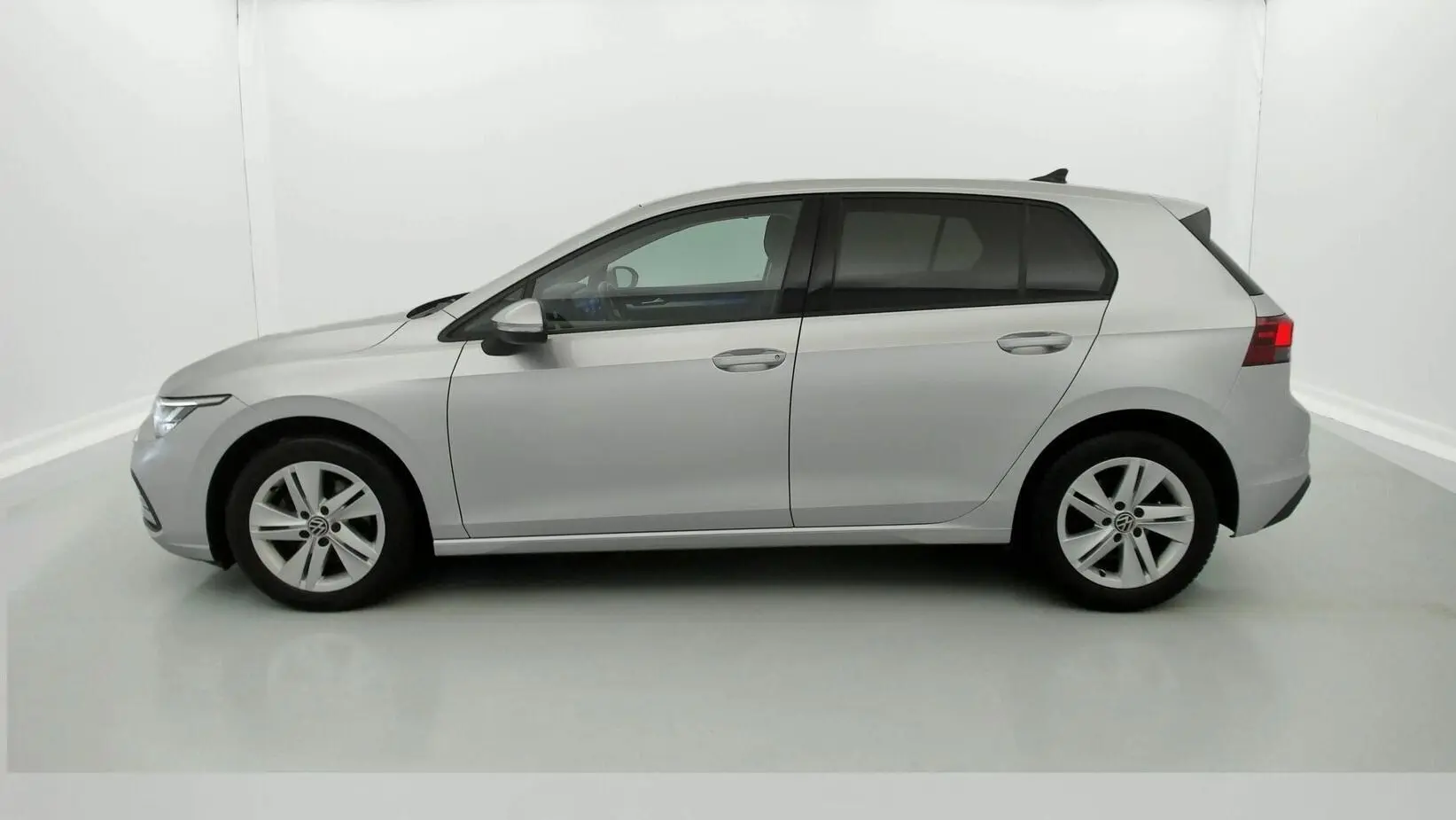 Profil droit d’une Volkswagen Golf VIII gris reflex, vue extérieure sur fond neutre, roues alliage 16 pouces visibles.
