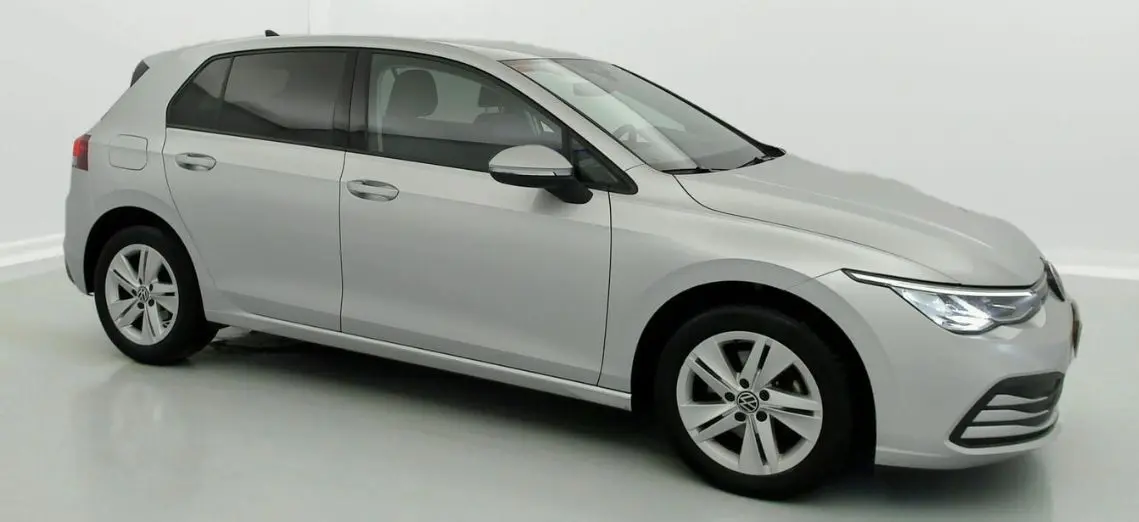 Volkswagen Golf VIII gris reflex vue de profil droit, avec jantes alliage 16 pouces et phares allumés.