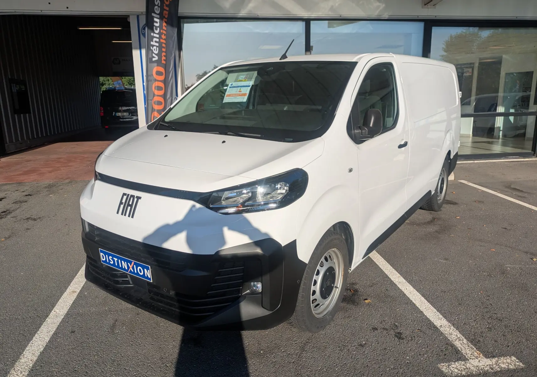 Fourgon FIAT Scudo XL blanc vu en 3/4 avant droit, avec jantes tôles grises et rétroviseurs noirs.