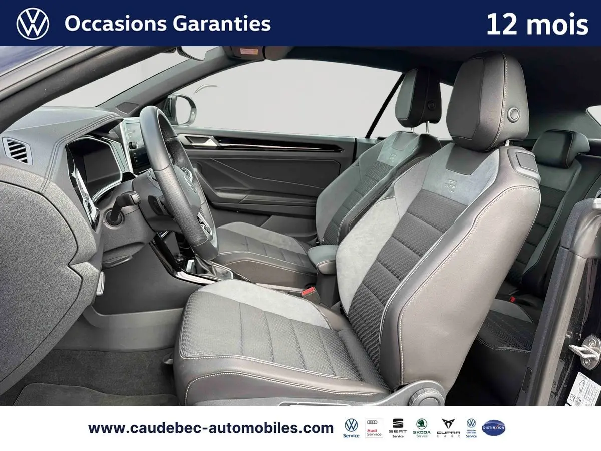 Vue intérieure côté conducteur du Volkswagen T-Roc Cabriolet noir 2025 avec sièges sport en cuir et alcantara gris.