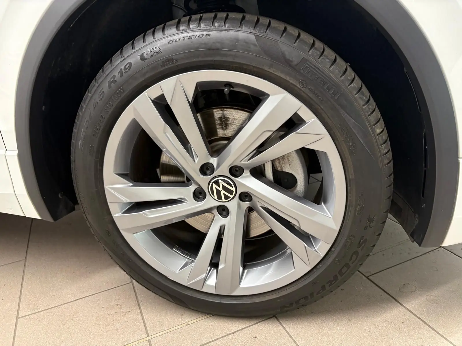 Gros plan sur la roue avant droite du Volkswagen Tiguan blanc pur 2023 avec jante alliage R-Line distinctive.