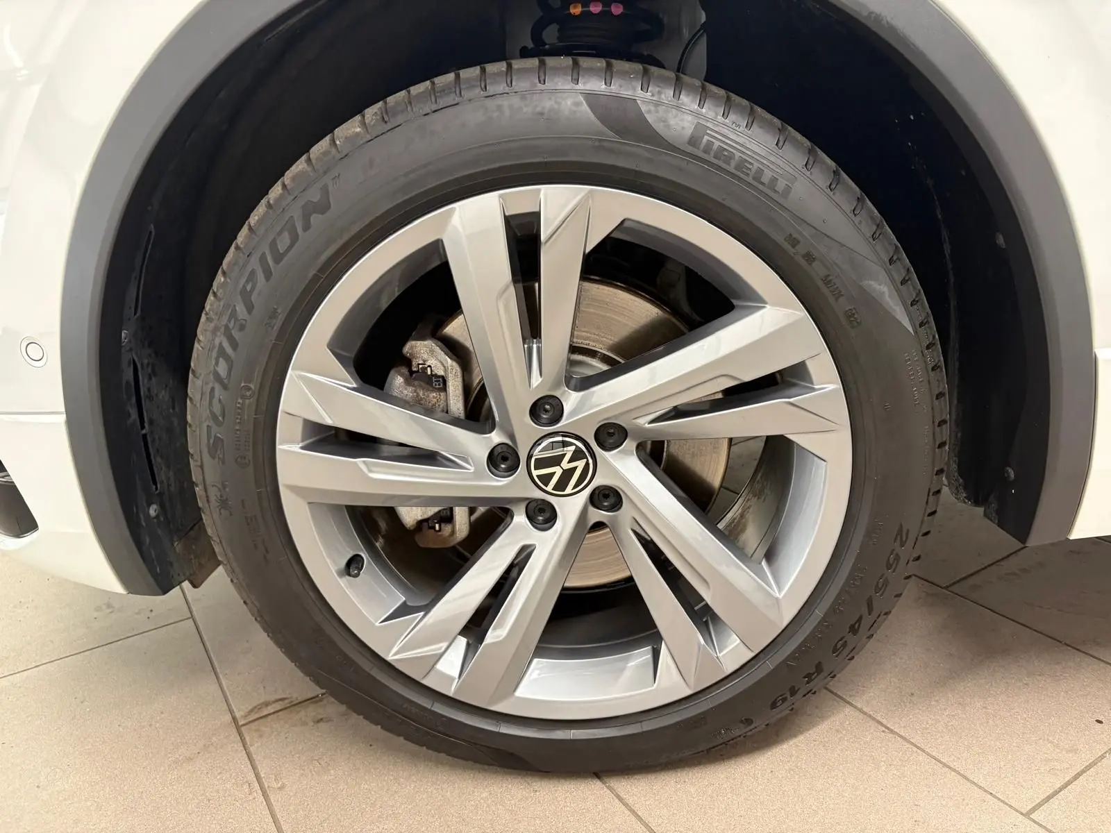 Gros plan sur la roue avant gauche du Volkswagen Tiguan blanc pur 2023 avec jante alliage R-Line distinctive.