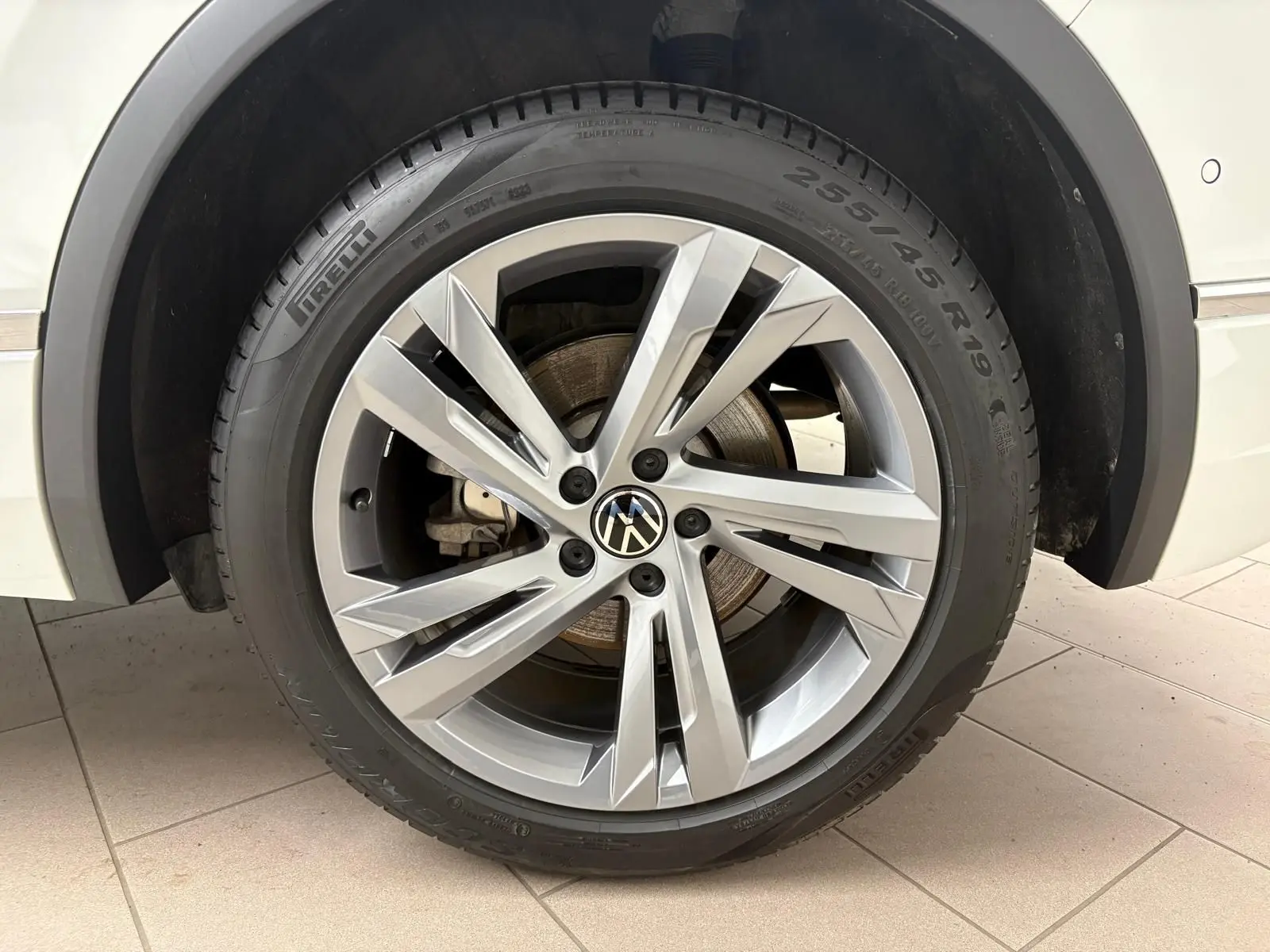 Gros plan sur la roue avant droite du Volkswagen Tiguan blanc pur 2023 avec jante alliage R-Line distinctive.