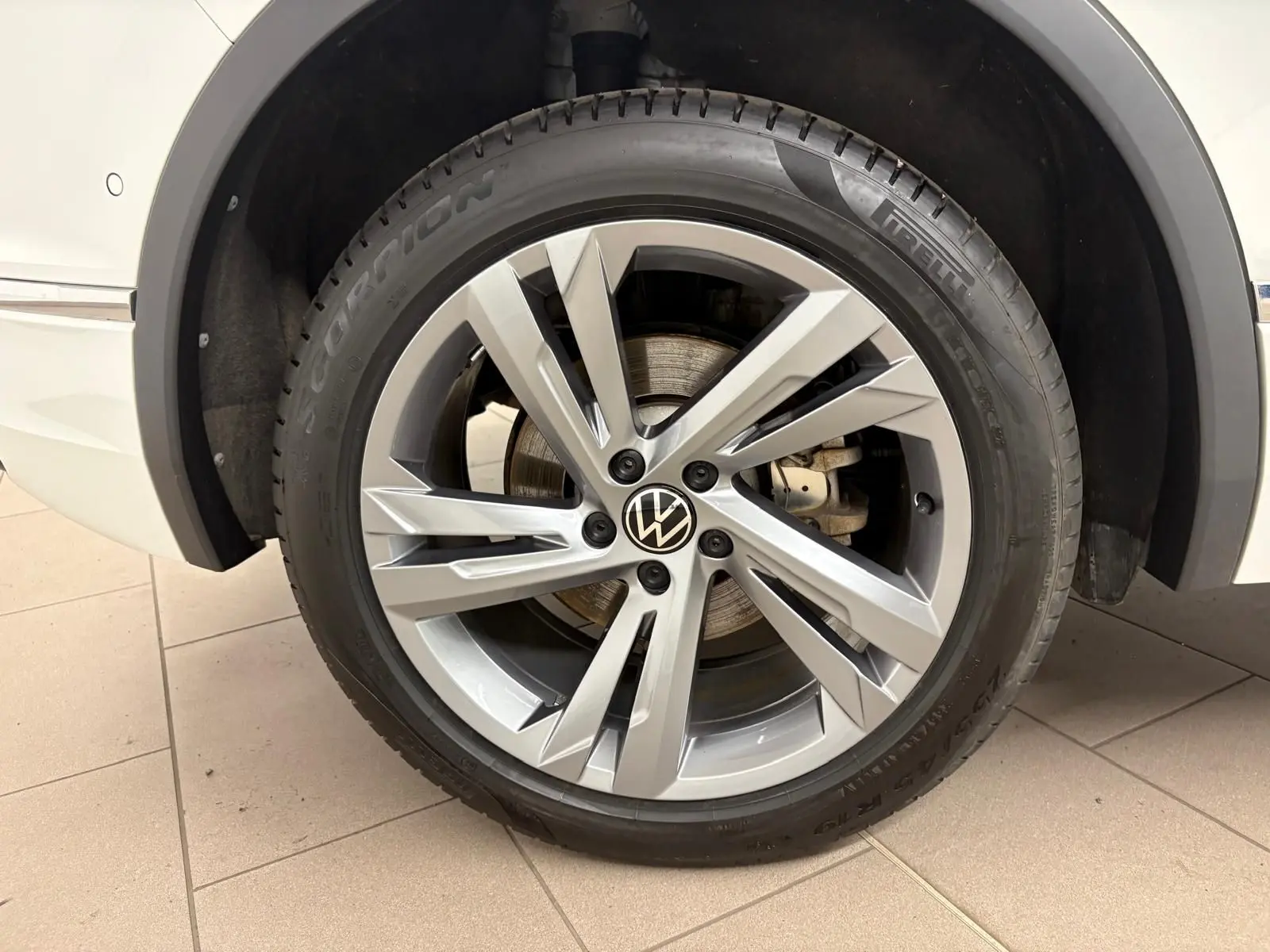 Gros plan sur la roue avant gauche du Volkswagen Tiguan blanc pur 2023 avec jante alliage R-Line distinctive.