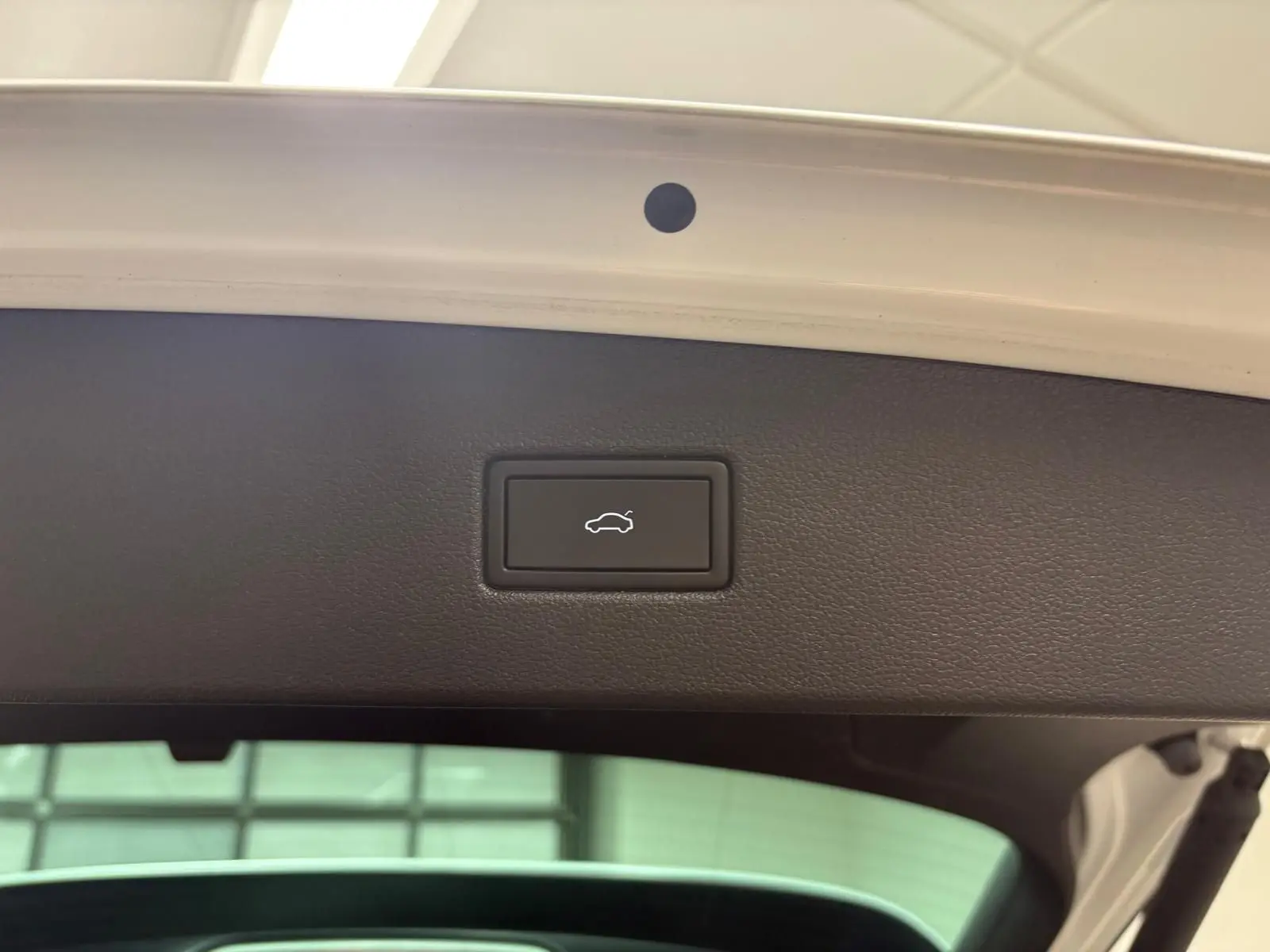 Bouton d'ouverture électrique du coffre sur la partie intérieure du hayon d'un Volkswagen Tiguan blanc pur 2023.