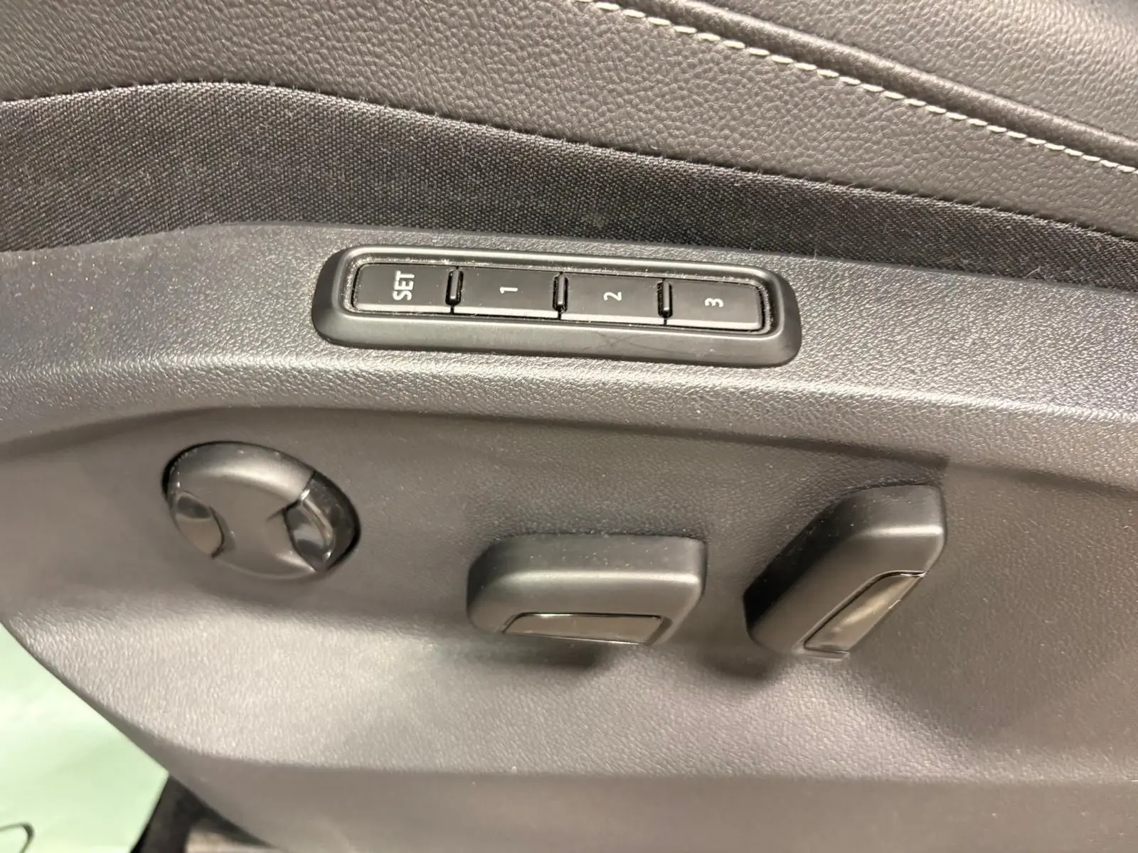 Réglages électriques des sièges avec mémoire sur la portière côté conducteur du Volkswagen Tiguan blanc pur 2023.