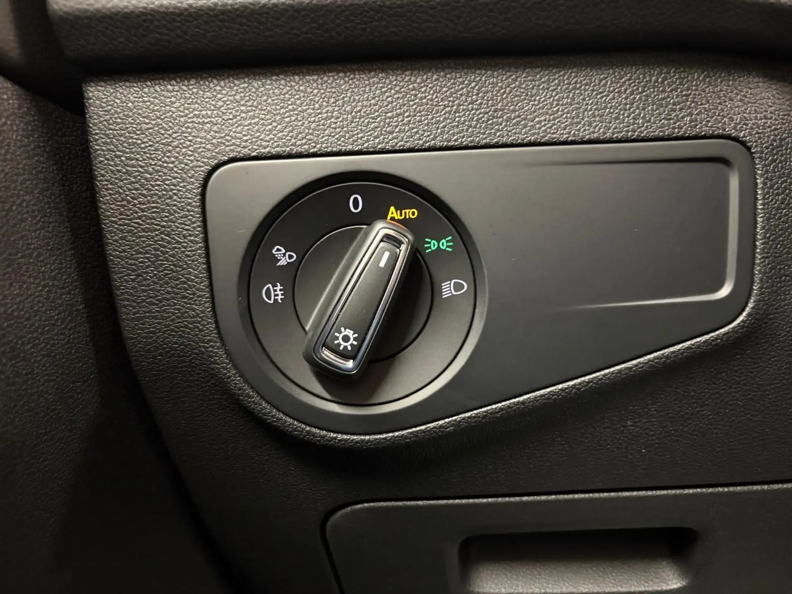Sélecteur d'éclairage en mode automatique sur tableau de bord noir du Volkswagen Tiguan 2023 blanc pur R-Line Exclusive hybride rechargeable.