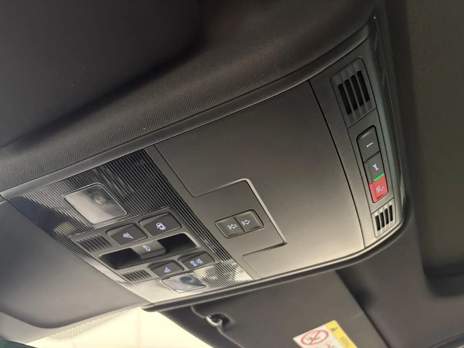 Plafonnier intérieur noir du Volkswagen Tiguan 1.4 eHybrid 2023 avec commandes et éclairage intégrés.