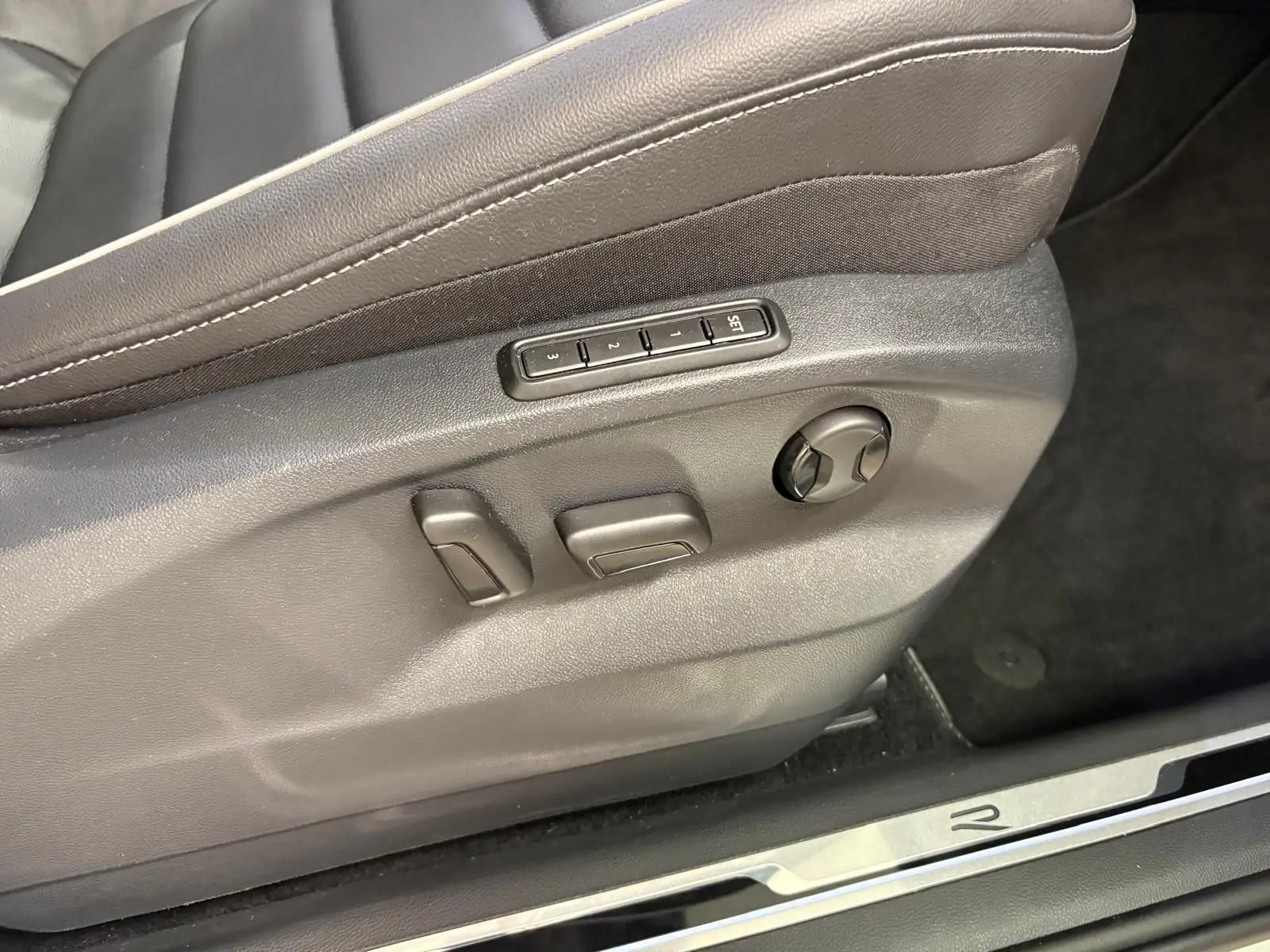 Gros plan sur les commandes de réglage électrique du siège conducteur en cuir noir du Volkswagen Tiguan 2023 R-Line Exclusive.