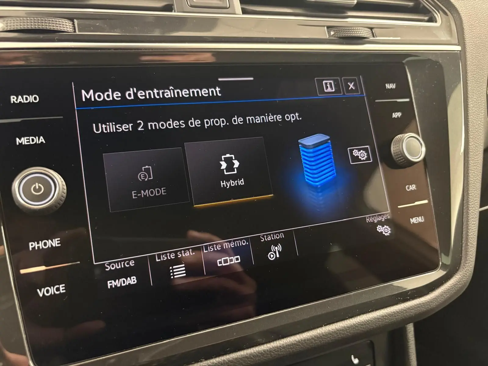 Écran tactile central du Volkswagen Tiguan 1.4 eHybrid 2023 affichant le mode d'entraînement hybride en intérieur noir.