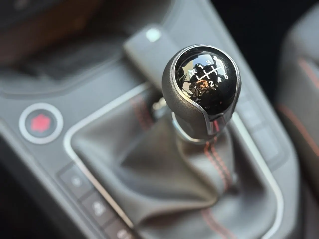 Le levier de vitesses manuel noir avec surpiqûres rouges de la SEAT IBIZA TSI 115 FR 2025 en gros plan intérieur.