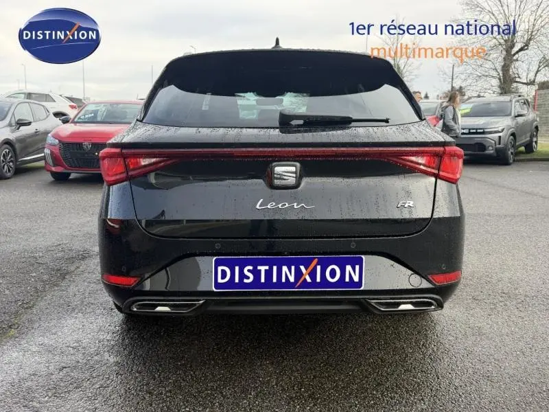 Vue arrière d'une SEAT LEON ST 2025 noir minuit métallisé avec logo FR et feux arrière continus lumineux.