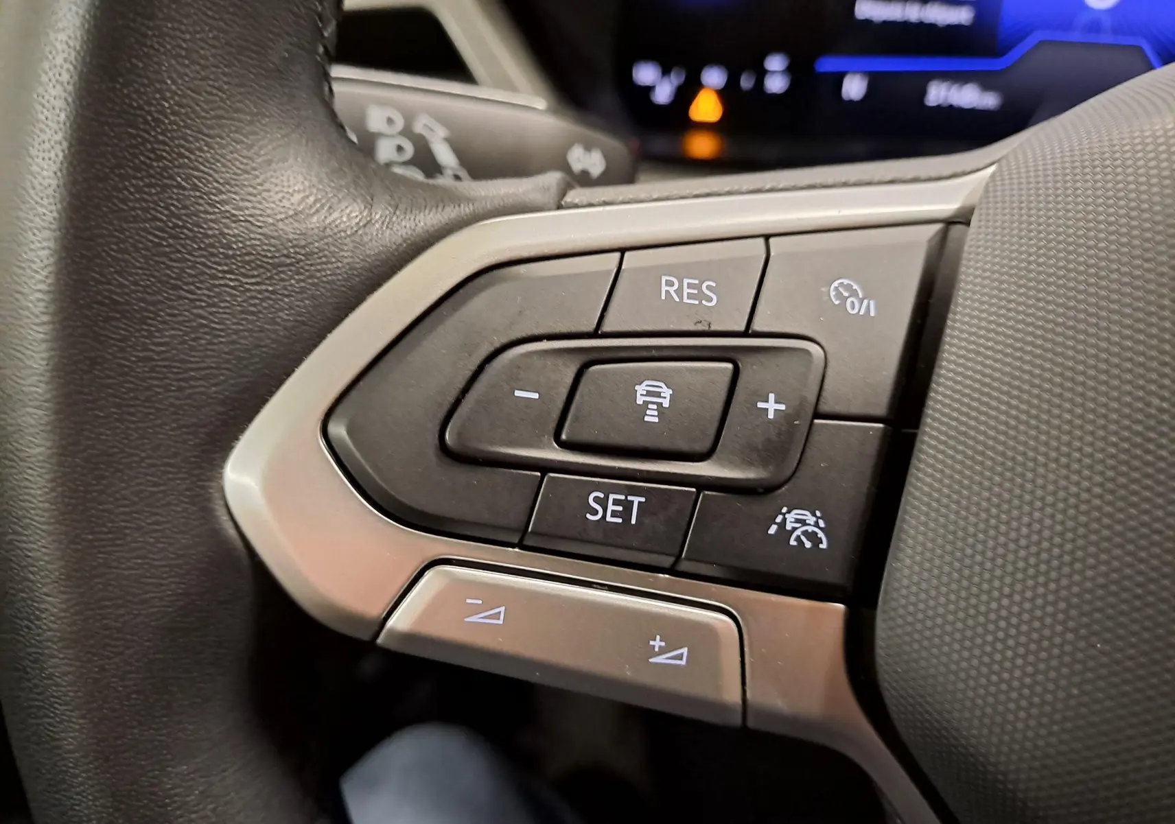 Gros plan sur les commandes au volant du Volkswagen Touran 2025, boutons de régulateur de vitesse et assistance au maintien de voie.