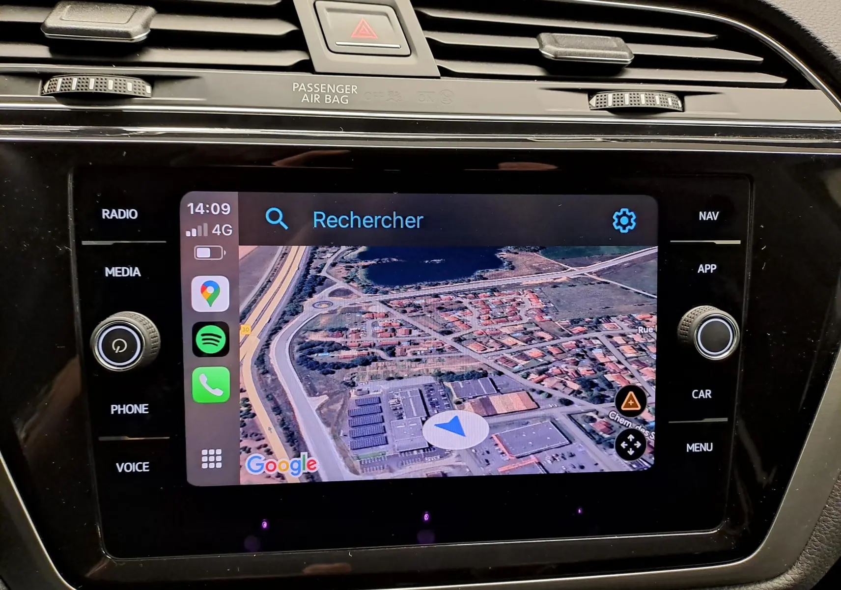 Écran tactile central du Volkswagen Touran 2025 affichant la navigation Google Maps avec commandes autour en finition noire brillante.