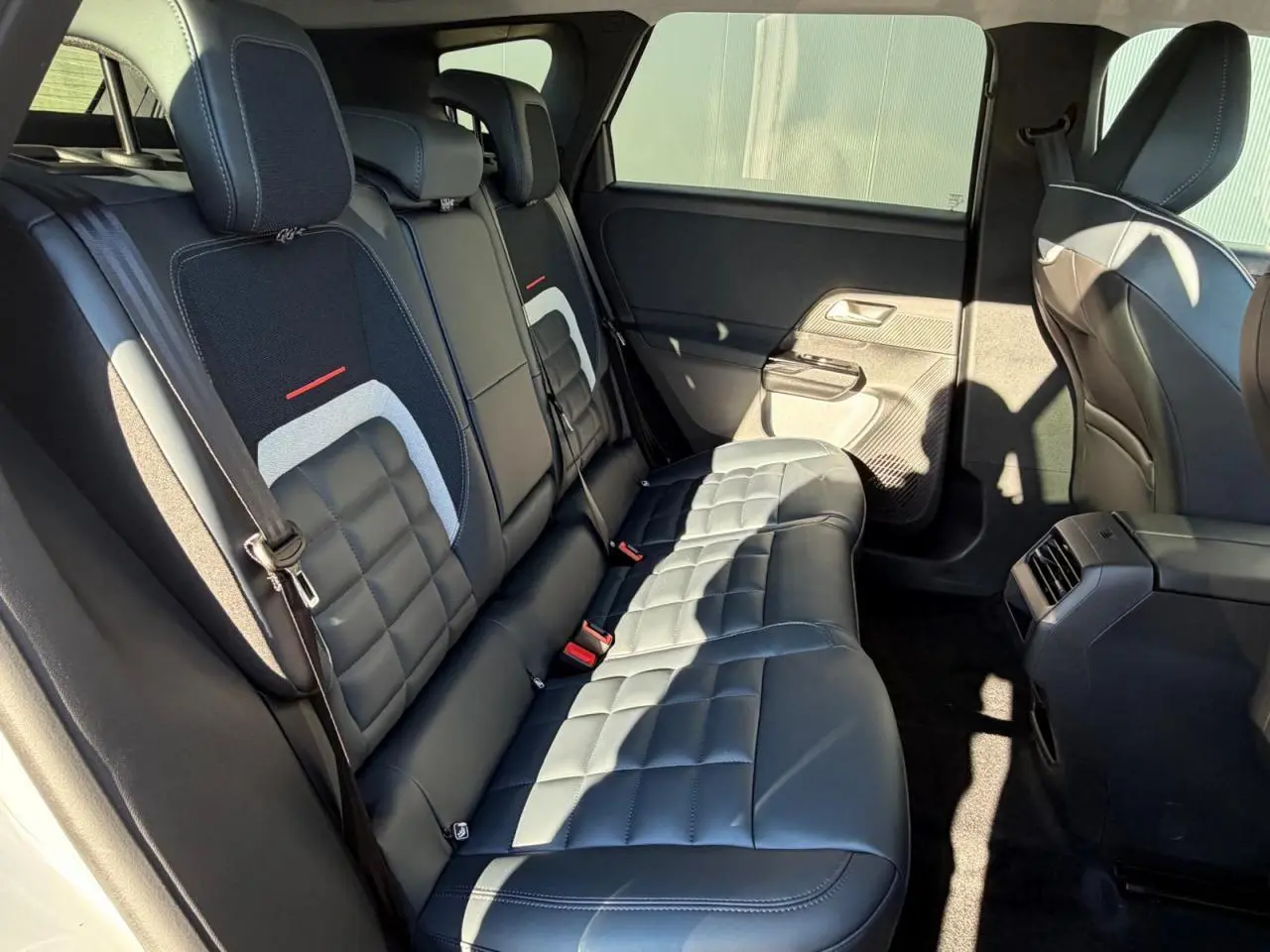 Vue côté droit de la banquette arrière en cuir noir avec surpiqûres et inserts textiles du Citroën C5 Aircross 2026.