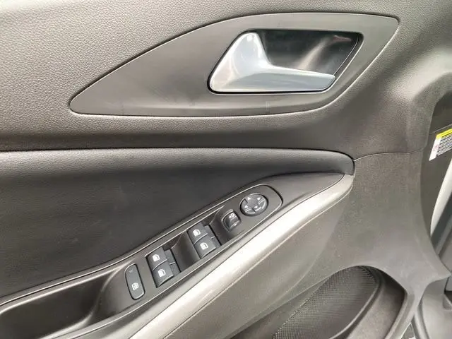 Gros plan sur la porte avant gauche noire de l'Opel Grandland 2024 avec commandes de vitres et poignée argentée.