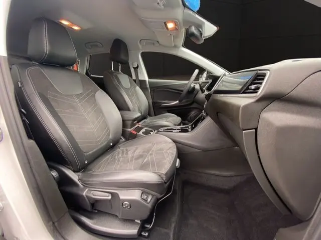 Vue intérieure côté droit de l'Opel Grandland 2024, sièges tissu/TEP noirs avec console centrale et tableau de bord modernes.