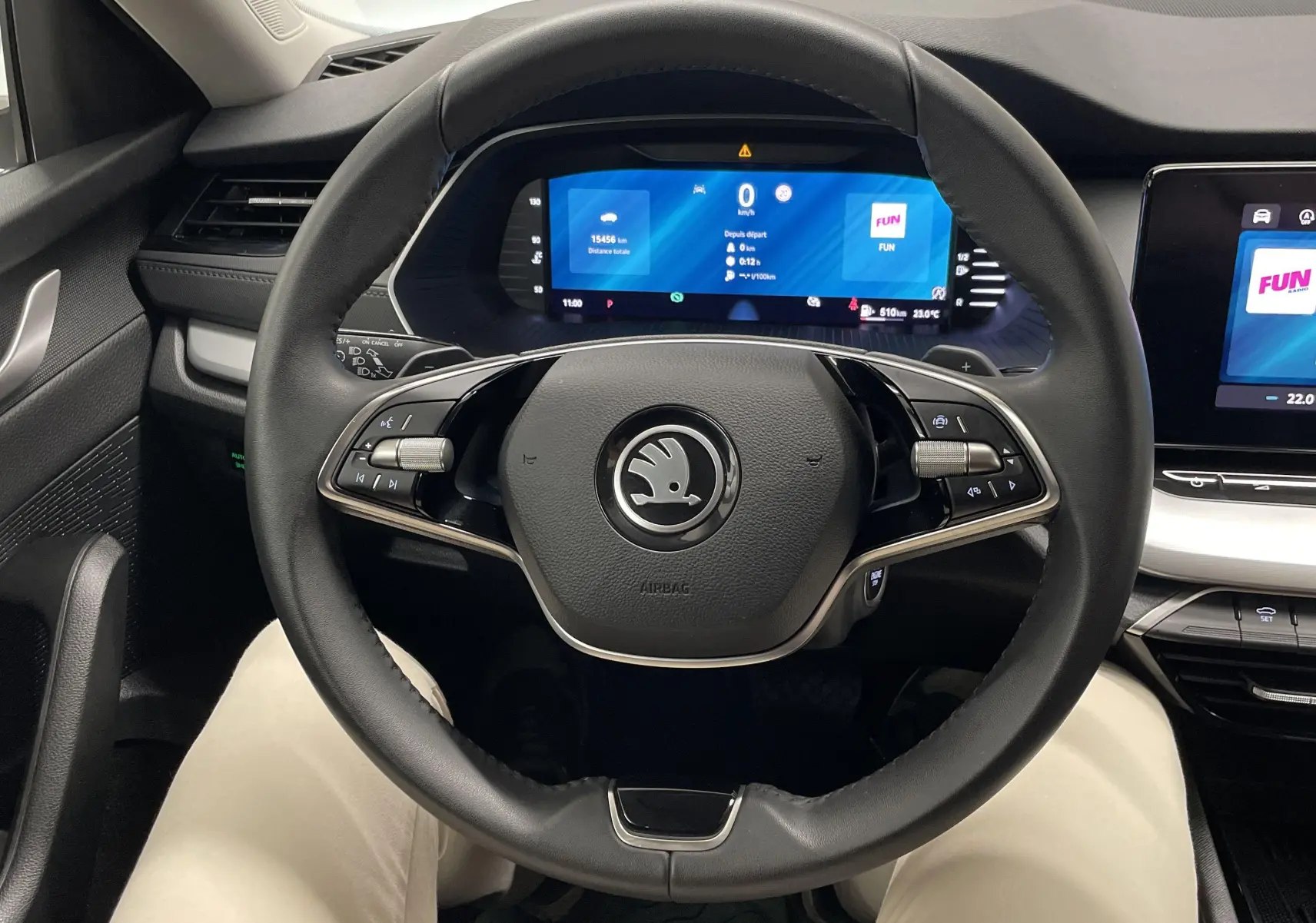 Vue depuis le siège conducteur du tableau de bord et volant noir d'une Skoda Octavia 2024 avec écran digital et commandes intégrées.