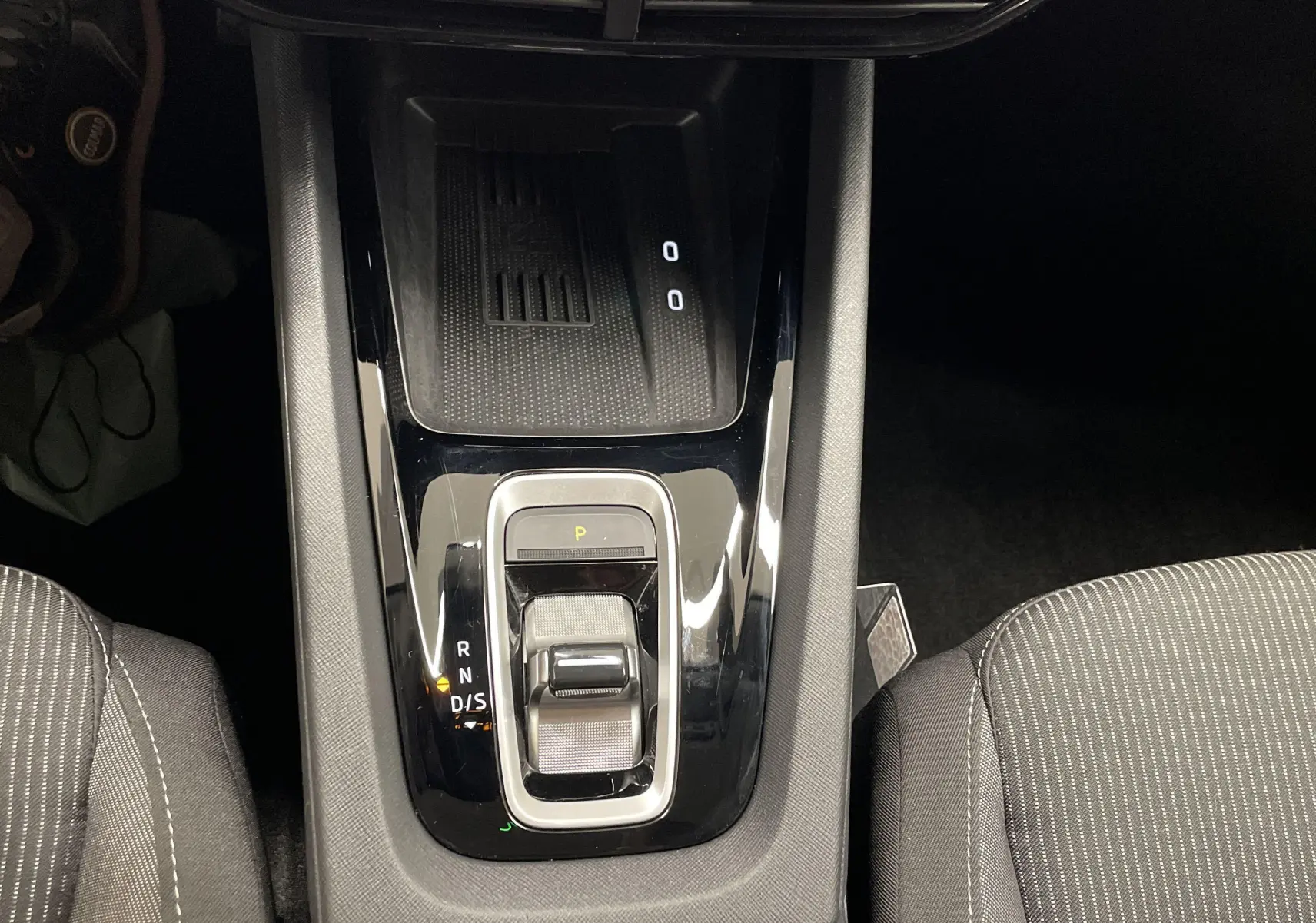 Vue plongeante sur la console centrale noire brillante de la Skoda Octavia 2024, avec levier de boîte automatique DSG7.