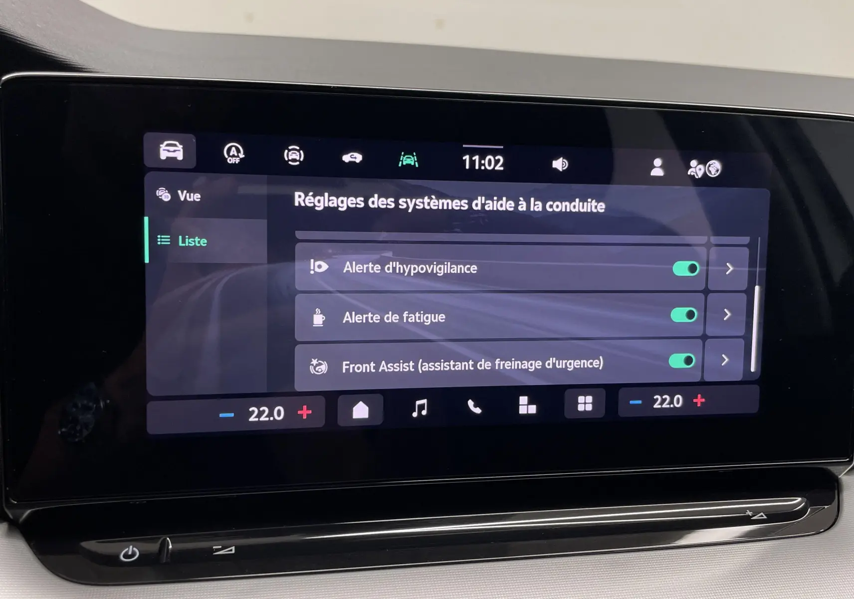 Écran tactile central de la Skoda Octavia 2024 affichant les réglages d'aide à la conduite dans un intérieur clair.