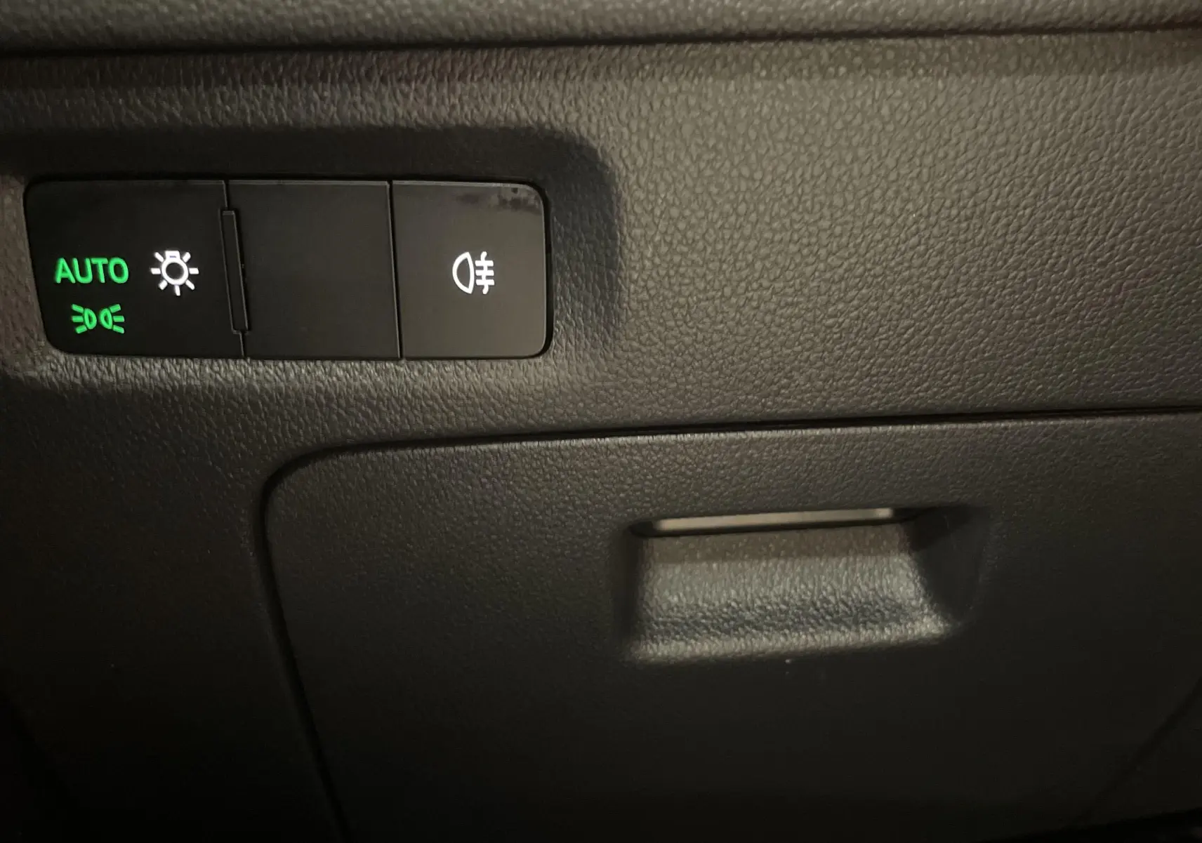 Panneau de commande des feux avec réglage automatique sur Skoda Octavia 2024, intérieur noir.