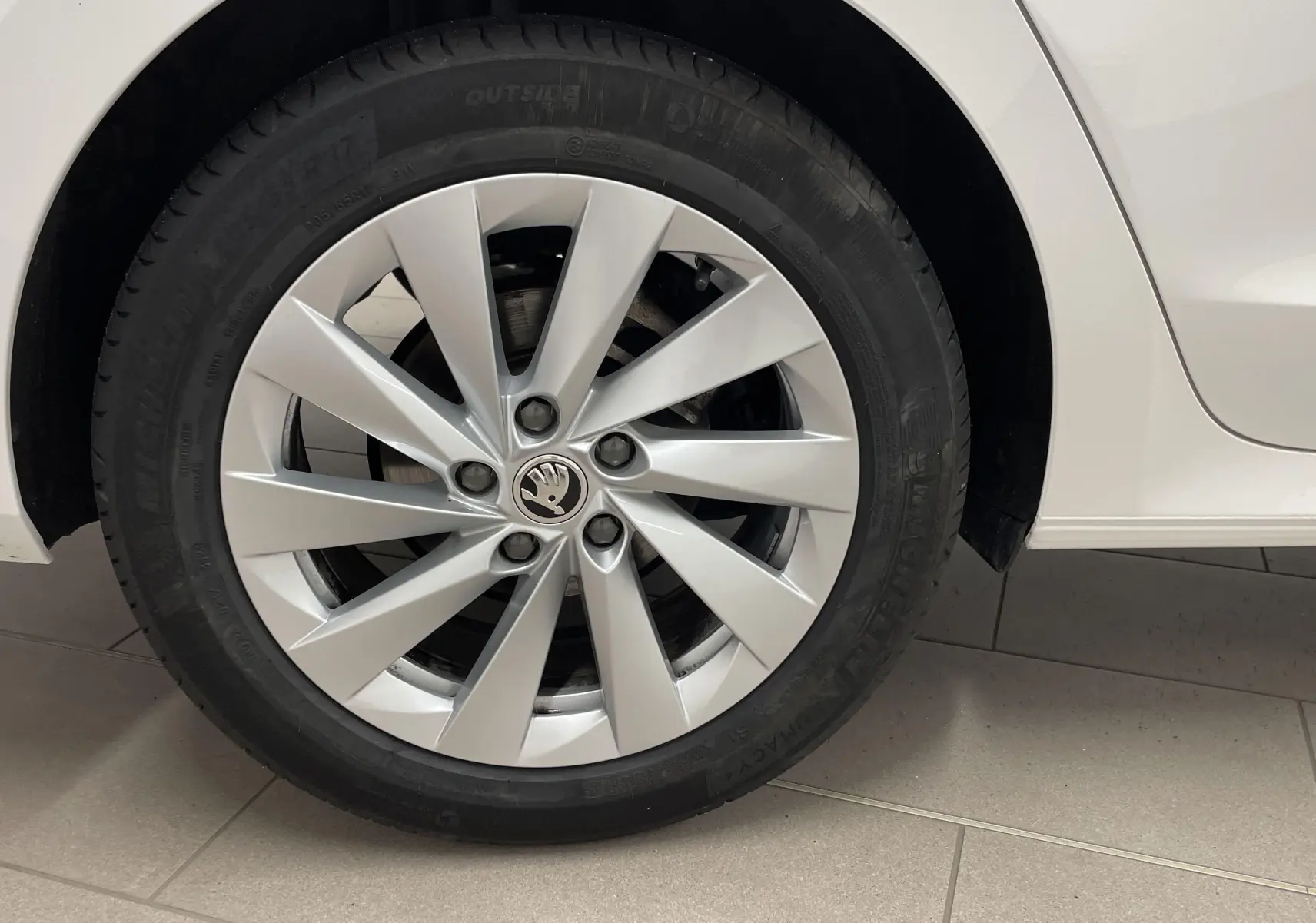 Gros plan sur la roue arrière droite blanche Candy d'une Skoda Octavia 2024 avec jante alliage et pneu Michelin galette.