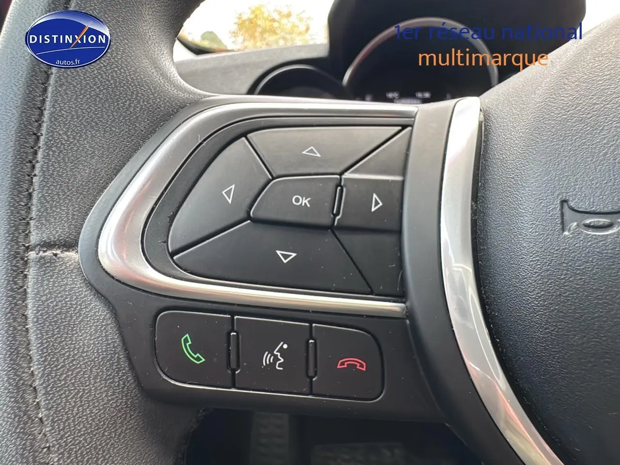 Gros plan sur les commandes multifonctions du volant cuir noir de la Fiat 500X rouge 2020 version Lounge