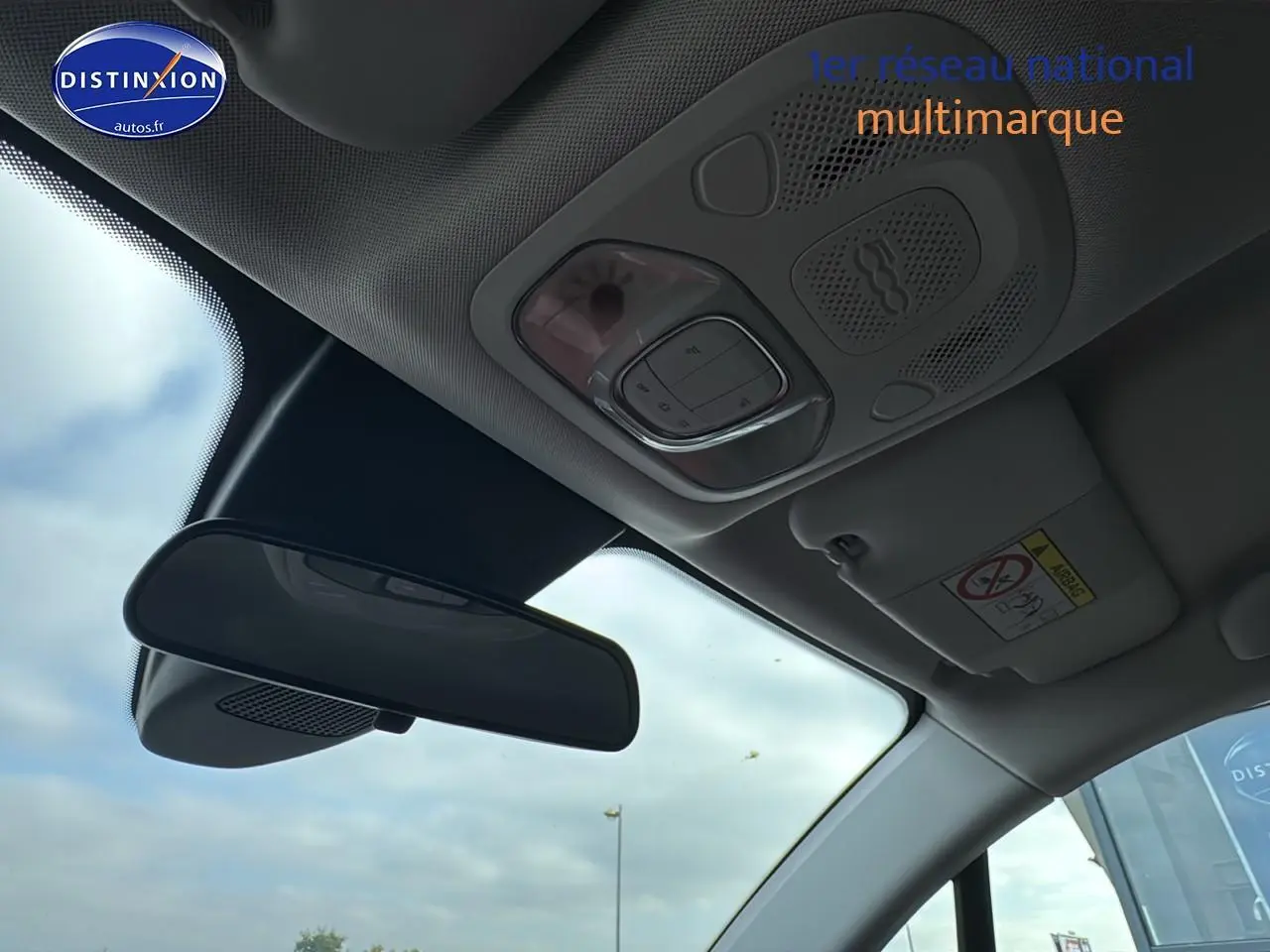 Vue intérieure du plafond avant de la FIAT 500X rouge 2020 avec rétroviseur et commandes d'éclairage intégrées.