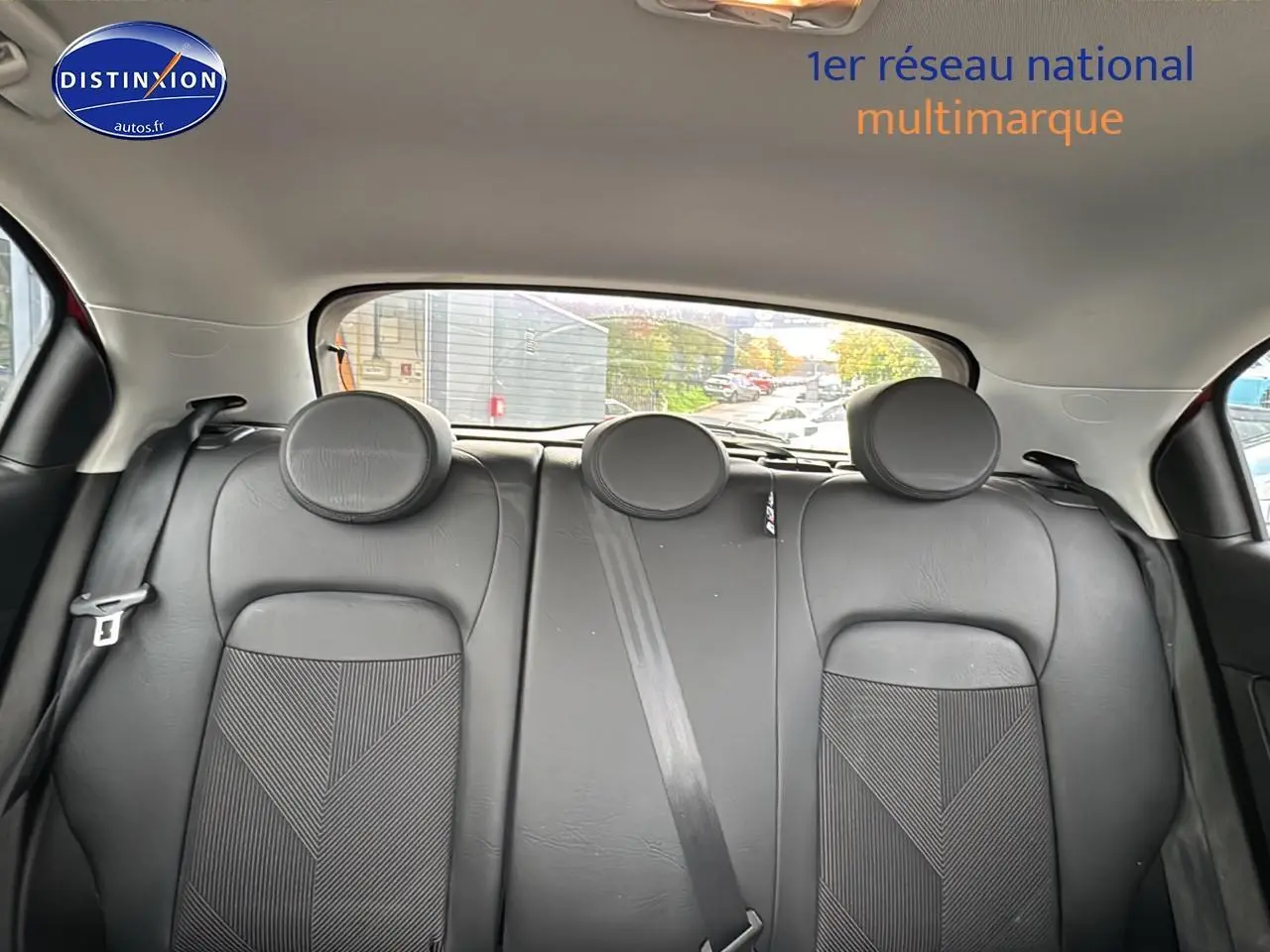 Banquette arrière en cuir noir avec appuie-têtes ronds dans une Fiat 500X rouge, vue de l'intérieur arrière.