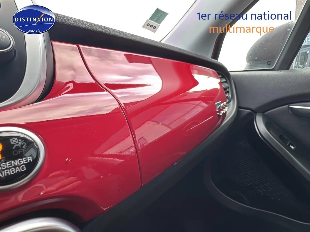 Tableau de bord rouge brillant côté passager du Fiat 500X 2020 avec détails intérieurs noirs et logo Fiat visible.