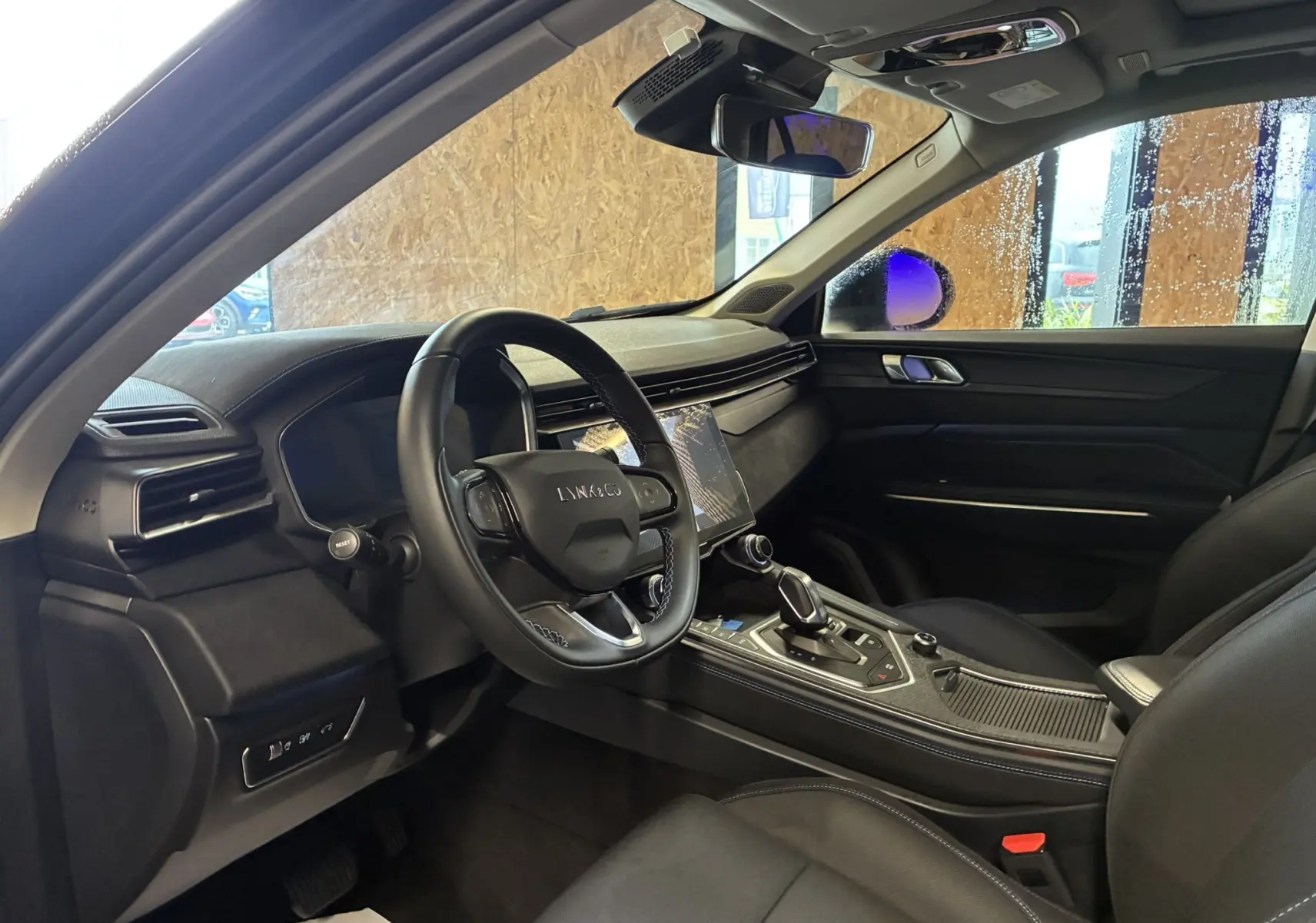 Intérieur noir du Lynk & Co 01 vu côté conducteur, avec tableau de bord moderne et écran tactile central.