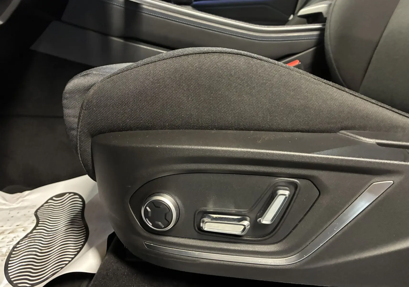 Gros plan sur les commandes électriques du siège avant gauche du LYNK & CO 01 hybride rechargeable bleu 2023.