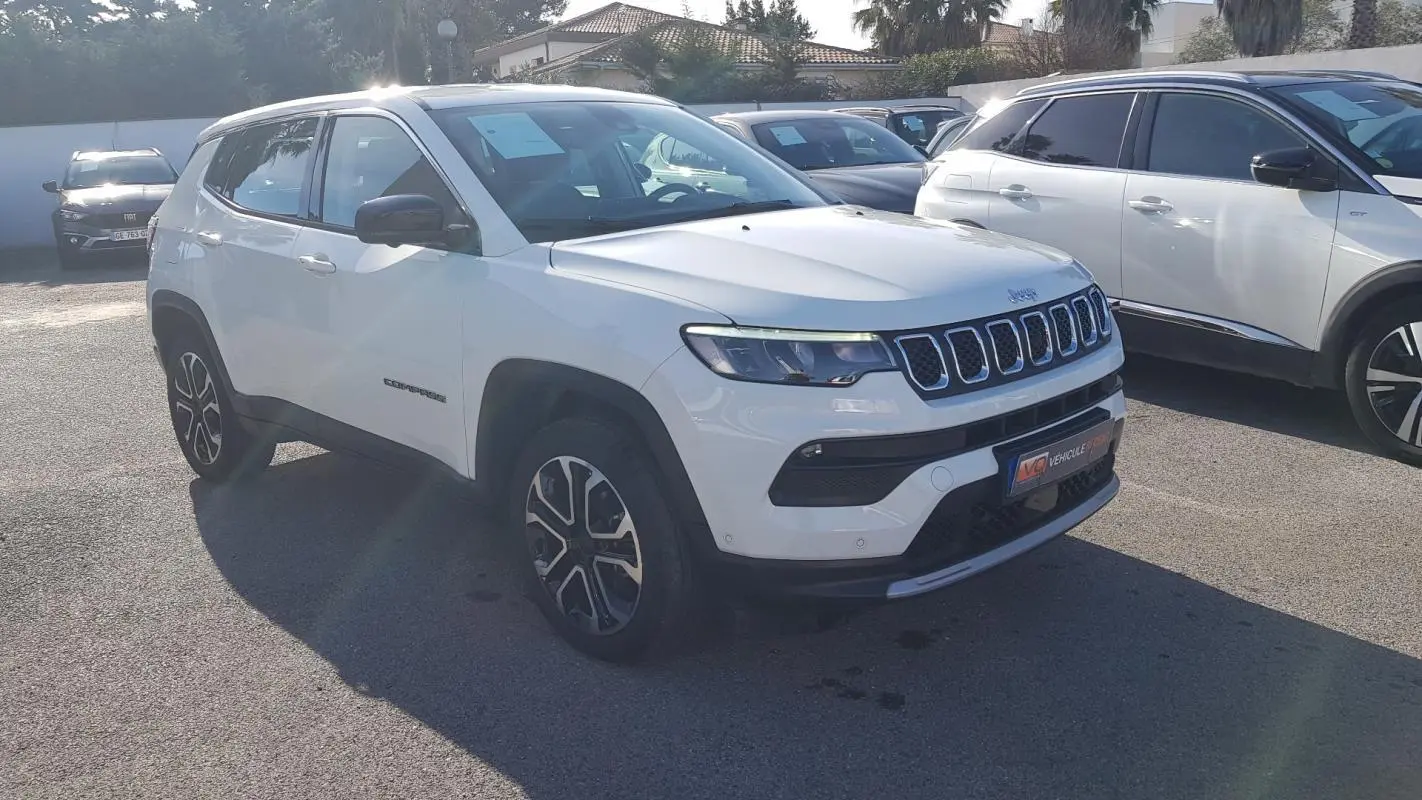 Jeep Compass blanc en vue 3/4 avant droit, avec jantes alliage 18 pouces et calandre distinctive à sept fentes.