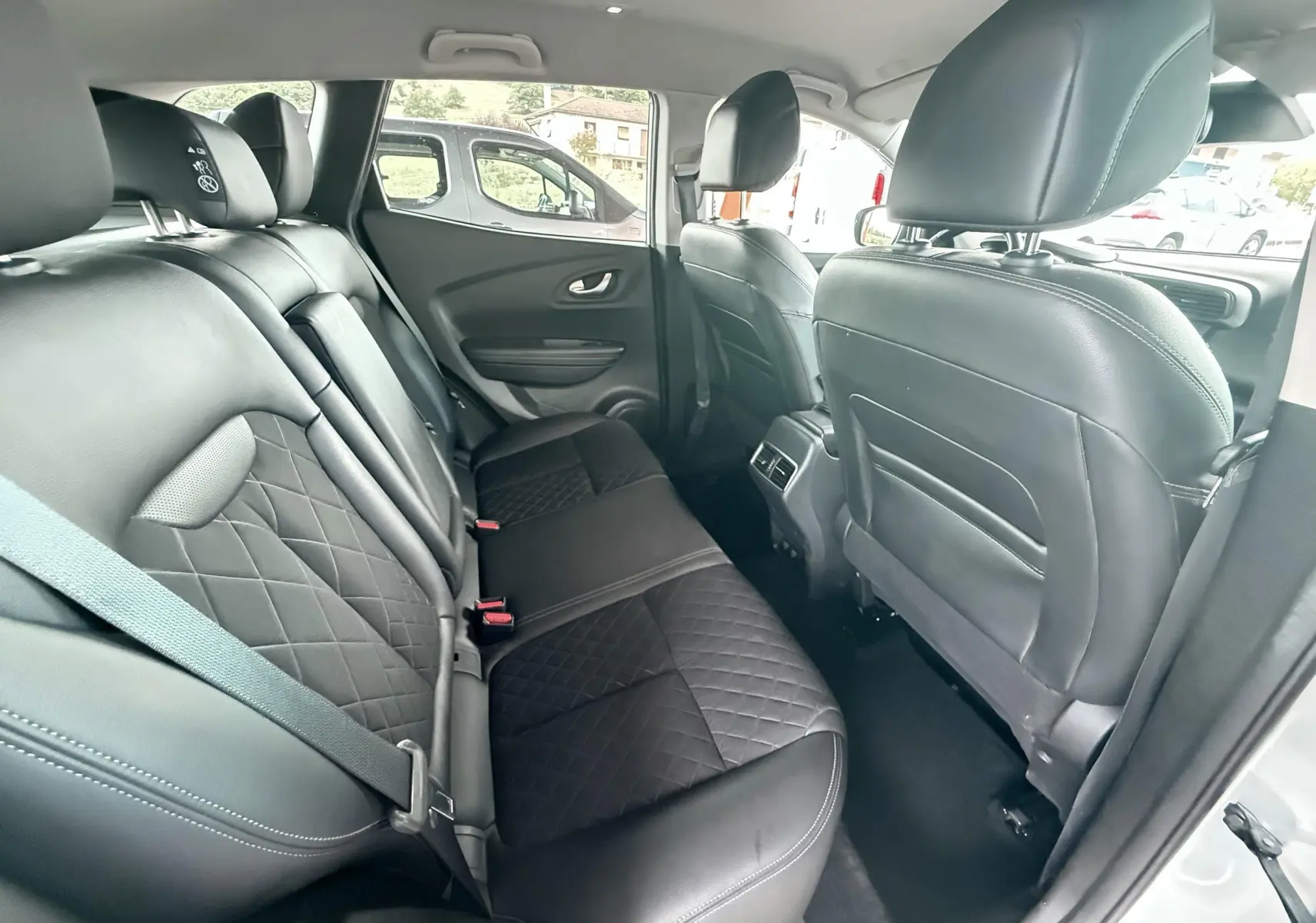 Vue intérieure arrière du Renault Kadjar 2020, sièges arrière en cuir noir avec surpiqûres losanges et ceinture grise.