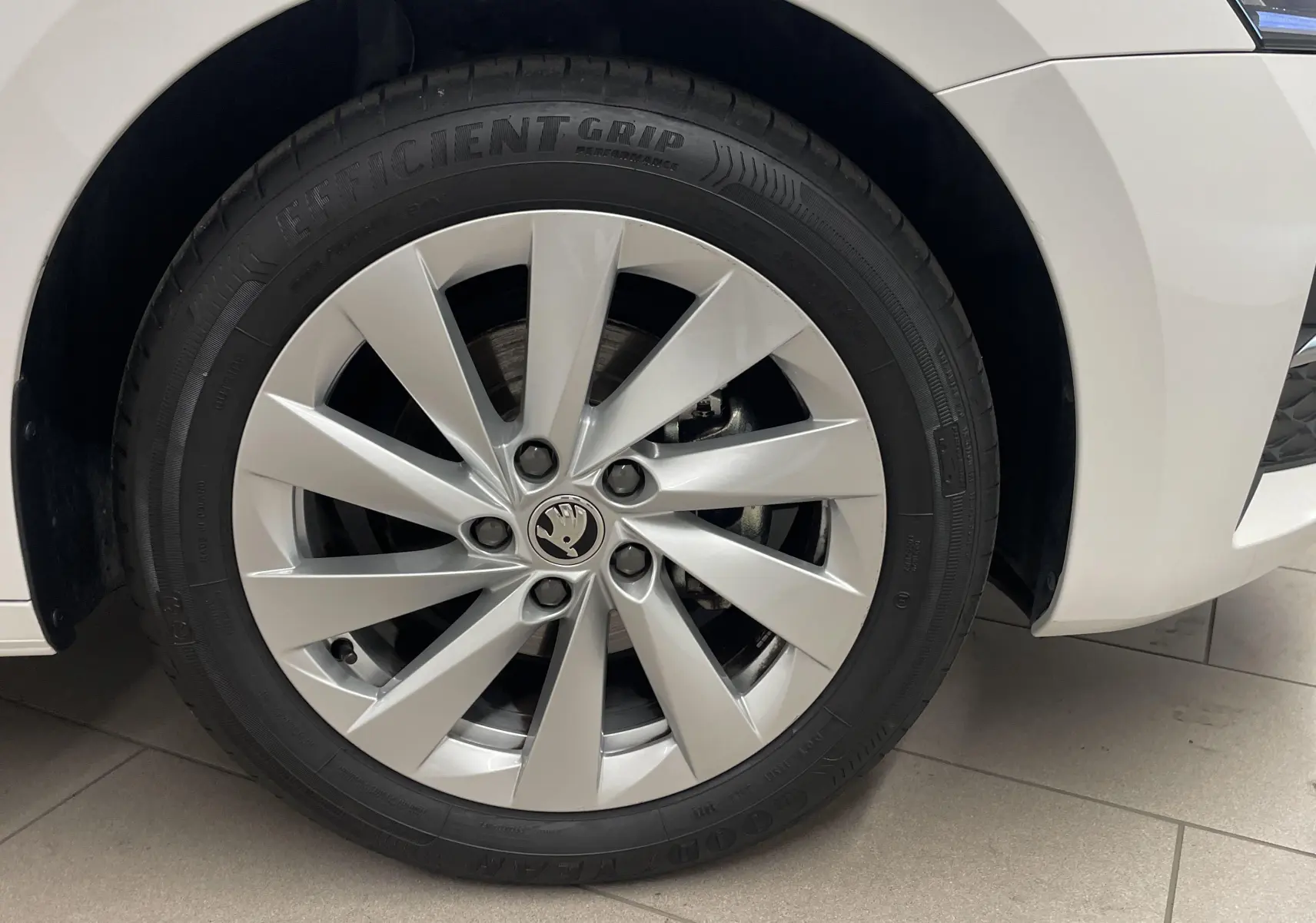 Gros plan sur la roue avant gauche blanche d'une Skoda Octavia 2024 avec jante argentée et pneu Efficient Grip.