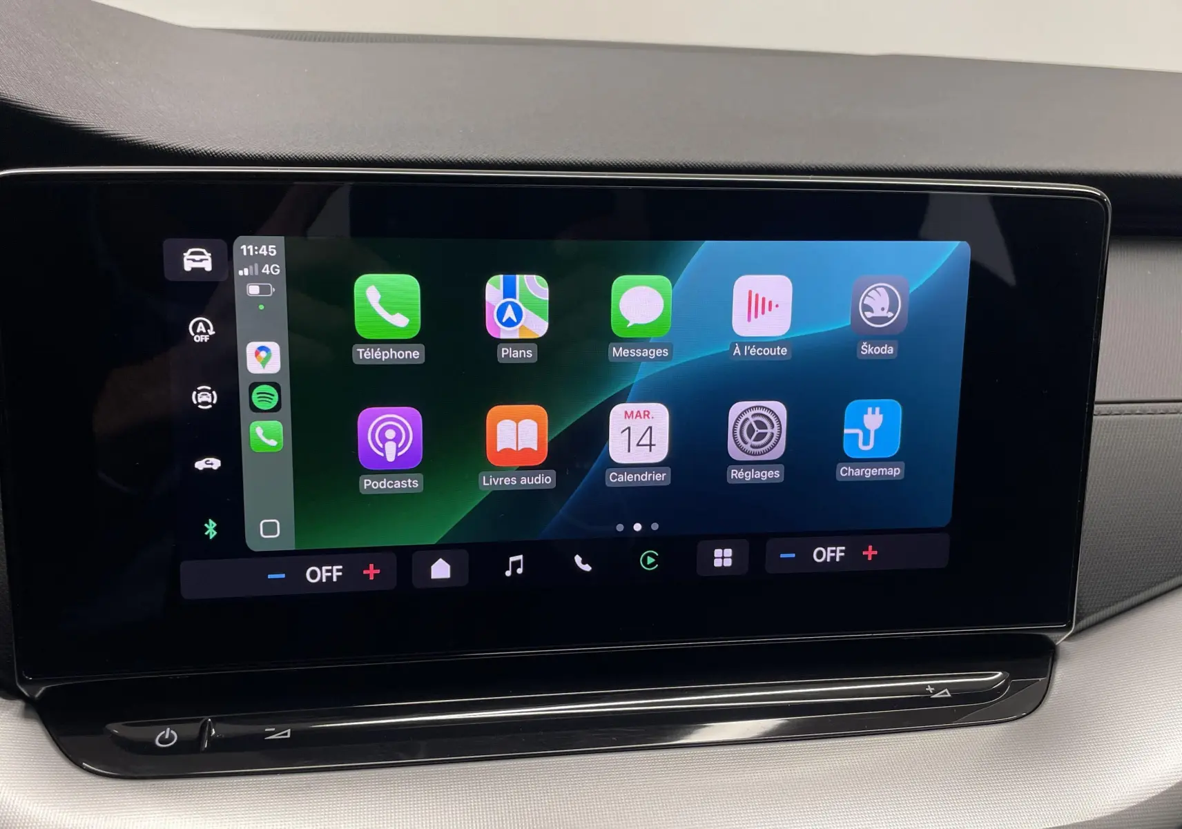 Écran tactile central de la Skoda Octavia 2024 affichant l'interface Apple CarPlay avec fond noir et éléments colorés.