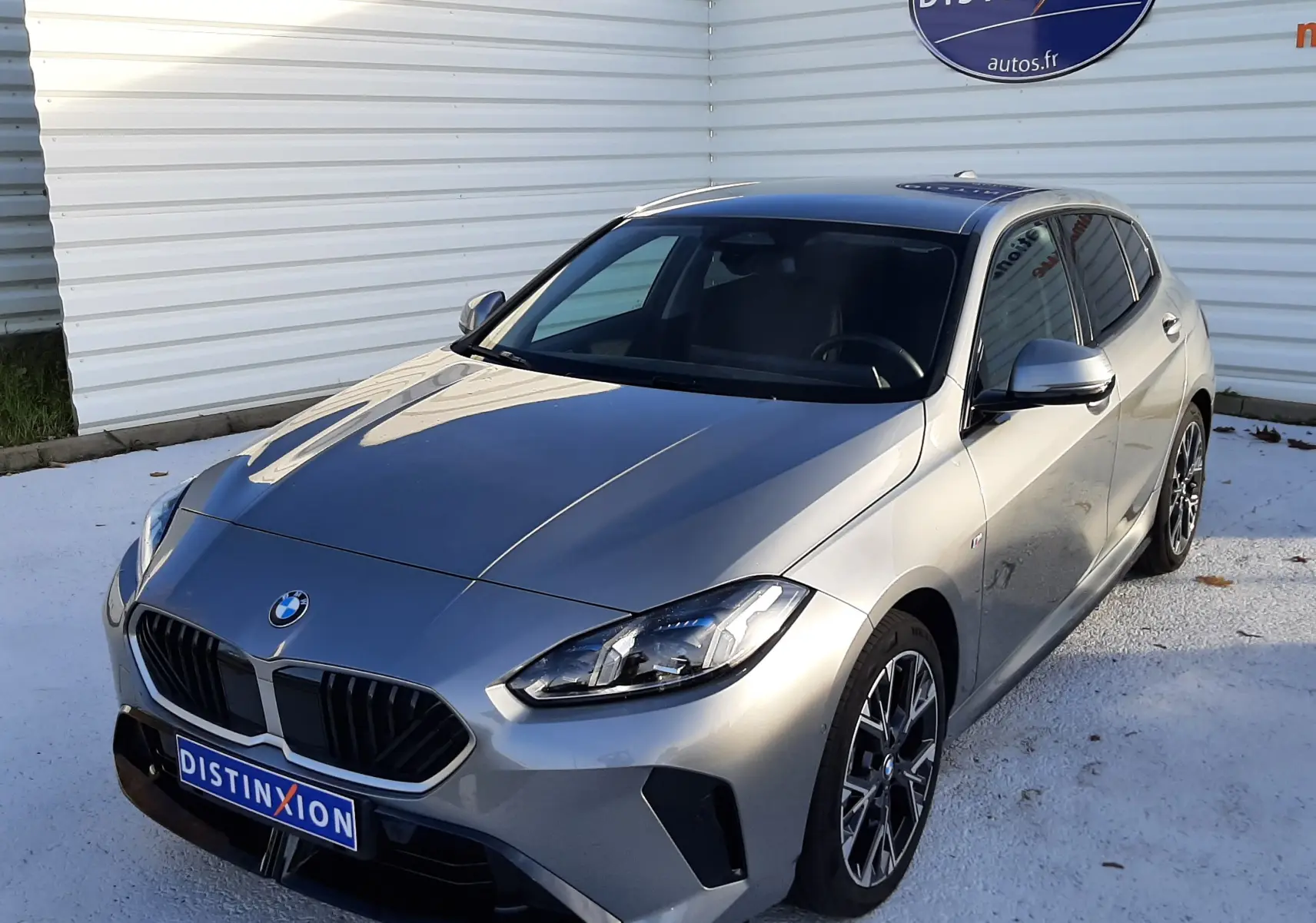 BMW Série 1 gris Skyscraper en 3/4 avant droit, avec jantes 18'' bicolores et calandre noire Shadow Line.