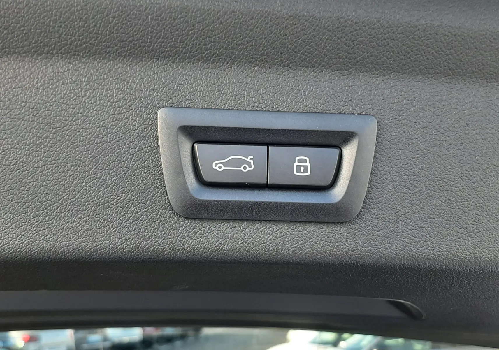 Boutons de commande électrique du volet de coffre et verrouillage sur la garniture intérieure du hayon gris Skyscraper BMW Série 1 F70.