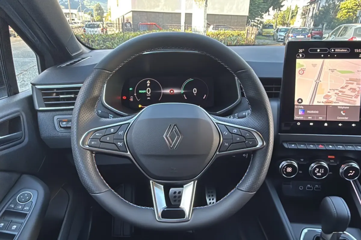 Vue intérieure centrée sur le volant Renault Clio V E-Tech 145 Esprit Alpine, avec tableau de bord numérique et écran tactile.
